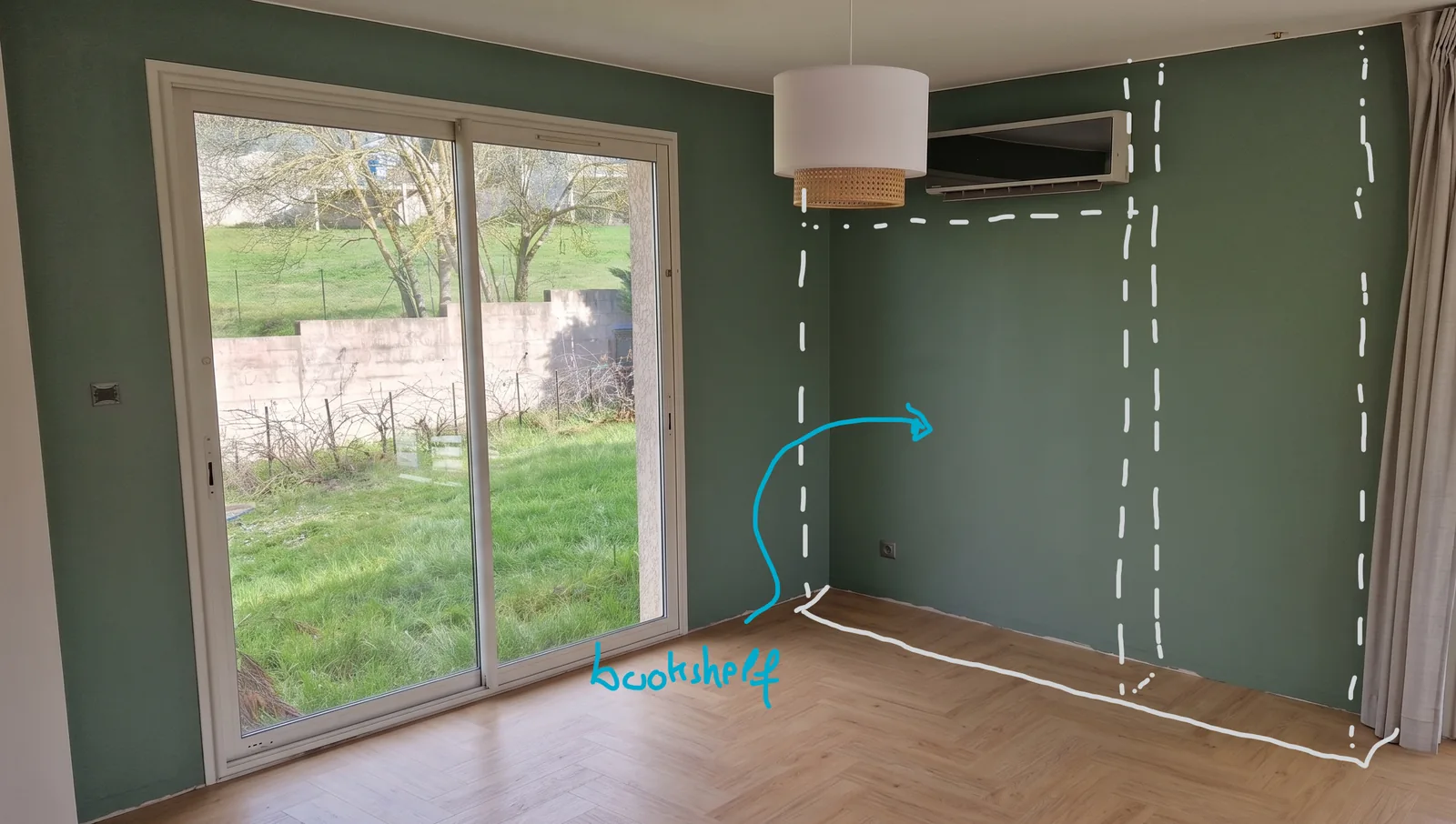 Empty green-walled room with a planned bookshelf outlined in white on the wall, sized from a 3D scan with no tape measure